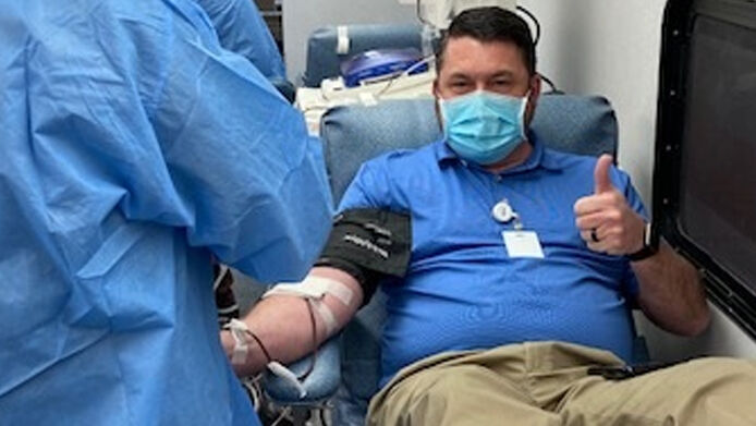 a man sitting reclined in a chair donating blood